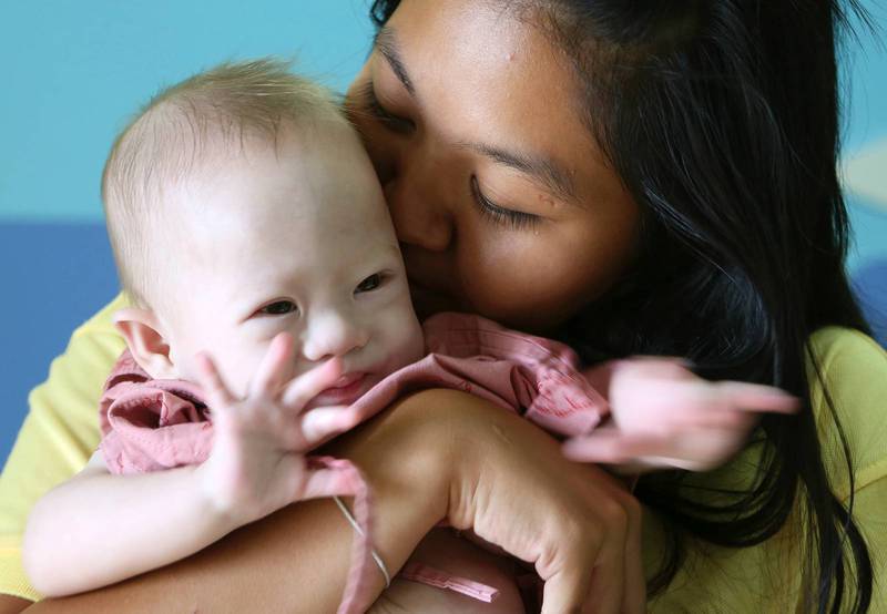 Pattaramon Chanbua pussar sin nyfödda son Gammy som föddes med Downs syndrom.
