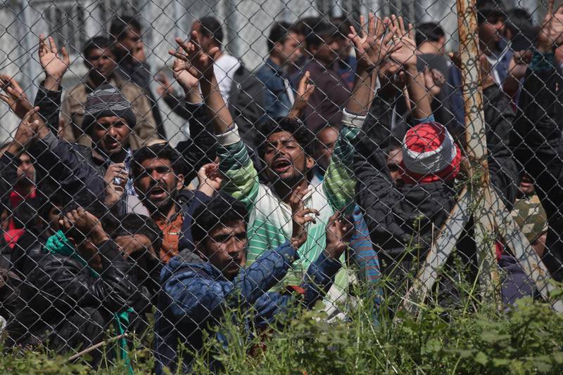 Migranter, de flesta från Pakistan, protesterar mot överenskommelsen mellan EU och Turkietinnanför stängslet på lägret i Moria på den grekiska ön Lesbos. (AP Photo/Petros Giannakouris)