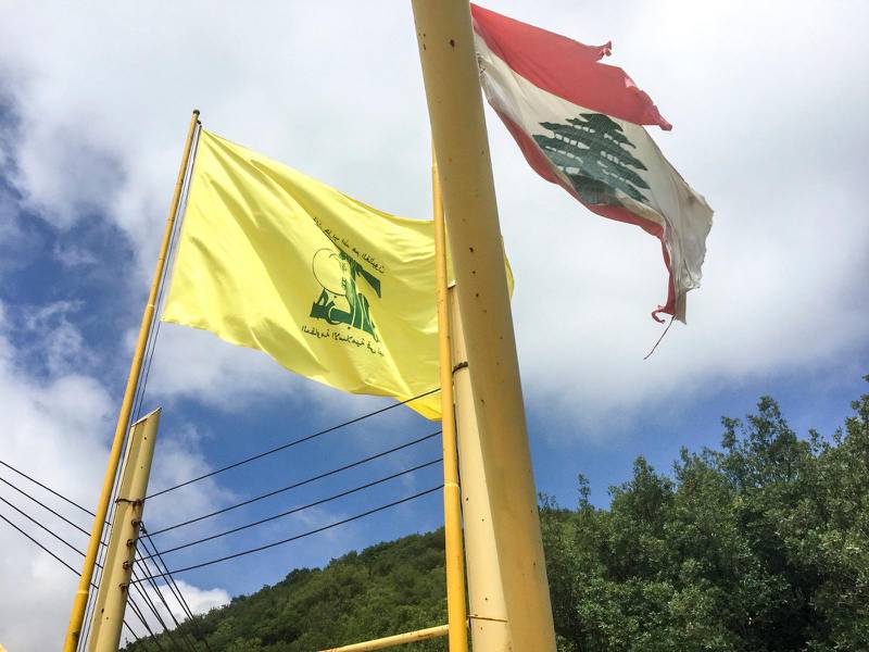 Gul och grön. Hizbollahs flagga vajar i vinden bredvid den libanesiska flaggan i södra Libanon.