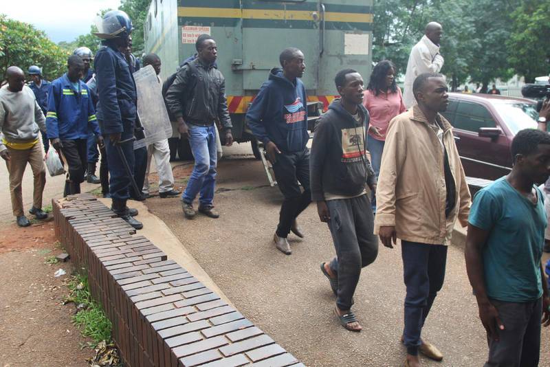 Personer som arresterats i samband med protesterna mot höjda bensinpriser i Zimbabwe i januari, på väg till domstolen i Harare.