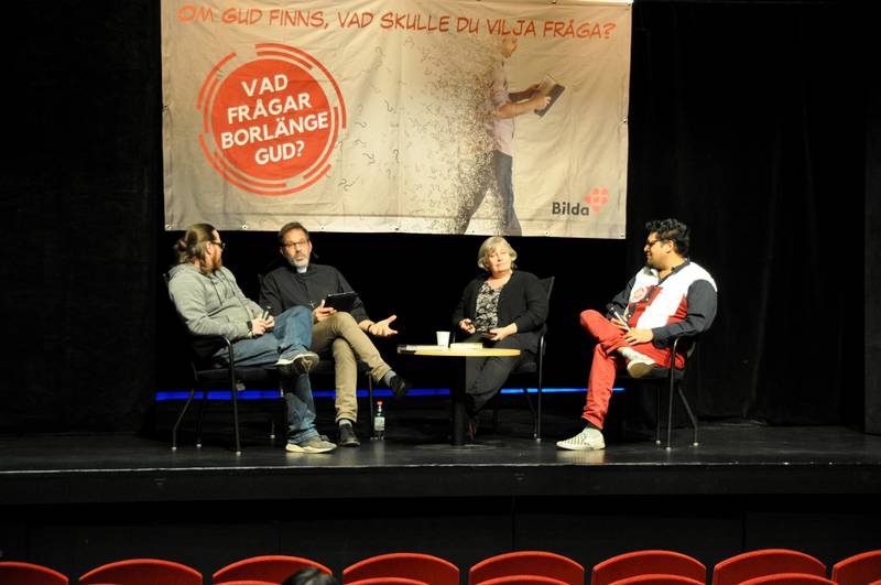 Fyra personer sitter på en scen och samtalar inför en publik.