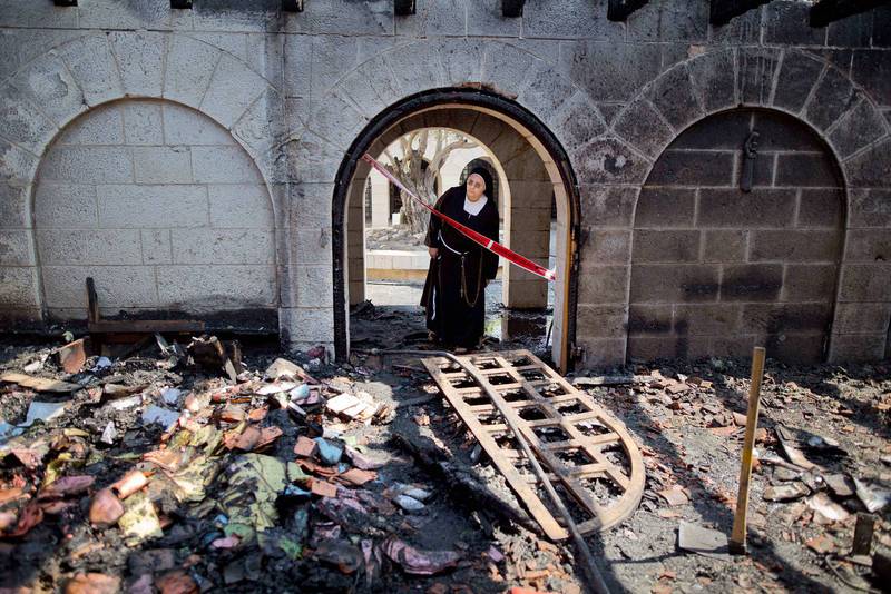 En nunna tittar in i den svårt eldskadade Mångfaldigandets kyrka.