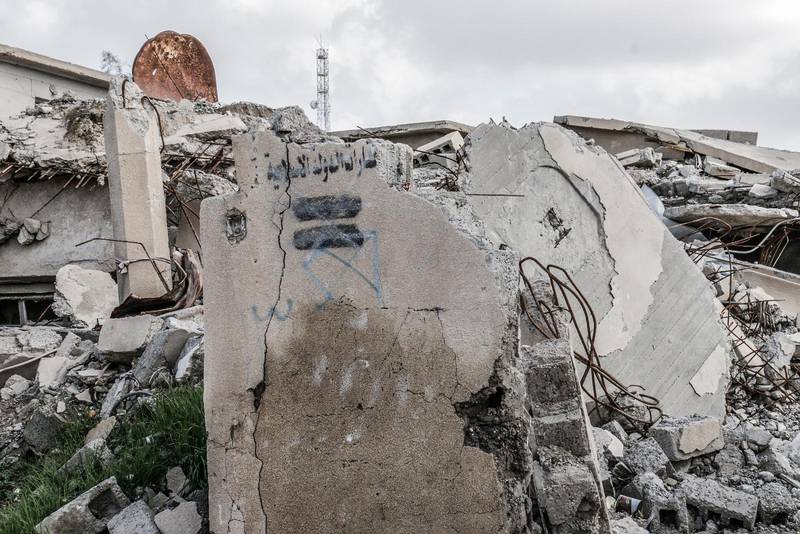 IS-märket kvar på väggen på sönderbombat hus.