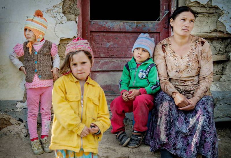 Liliana Serban, 31, sitter utanför sitt hus i Pauleasca tillsammans med grannbarnen Adriana Tamas och Renata Maghiran och hennes son Rais. Romerna i Rumänien möts ofta av rasism från grannar och myndigheter.