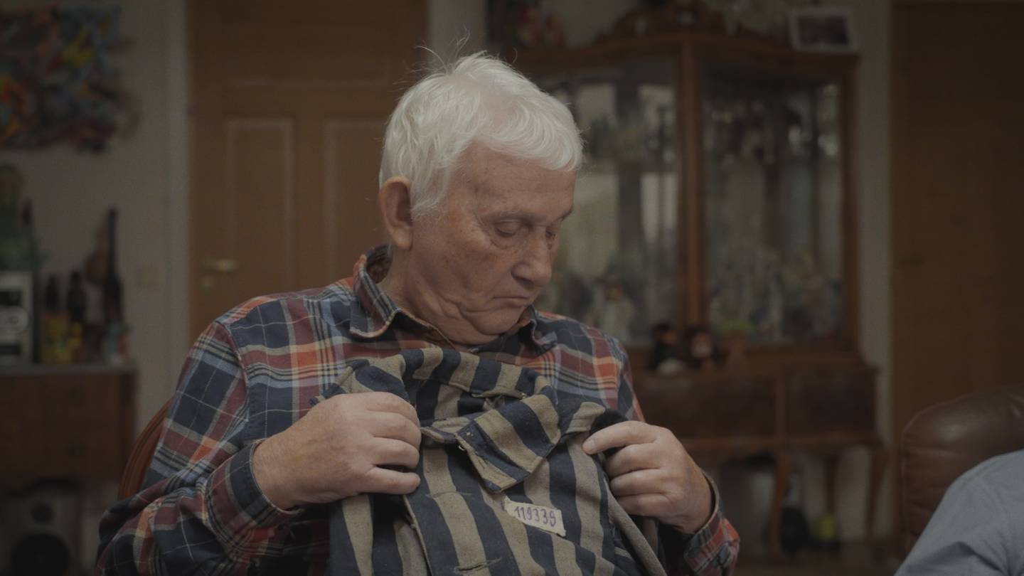 Kiwa Zyto visar upp sin jacka från Auschwitz då han berättar om sina minnen från Förintelsen.