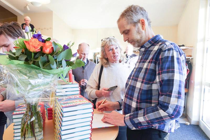 Joachim Elsander signerar sin bok ”På väg” under bokrealesen i Korskyrkan Borlänge.