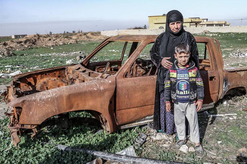 Bahja Fadhil Muhammed visar sonens utbrända bil efter att IS förde bort och dödade honom. Här med barnbarnet Yusuf Atiye Yasin, sju år.