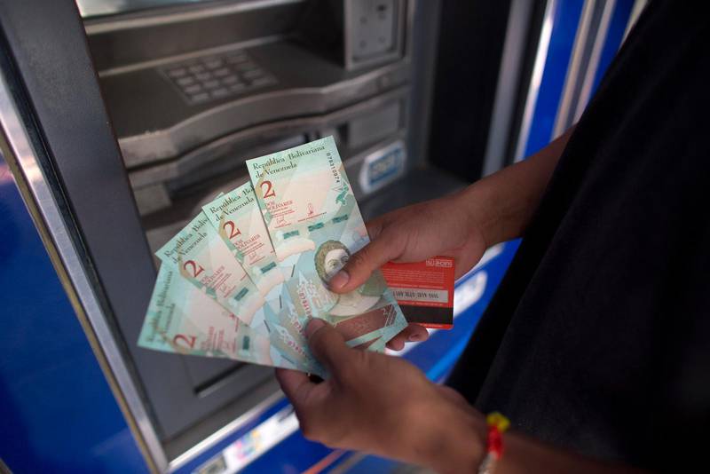 En man visar upp de nya sedlarna som Venezuela införde i tisdags i ett försök att stoppa hyperinflationen. (Bild från Caracas).