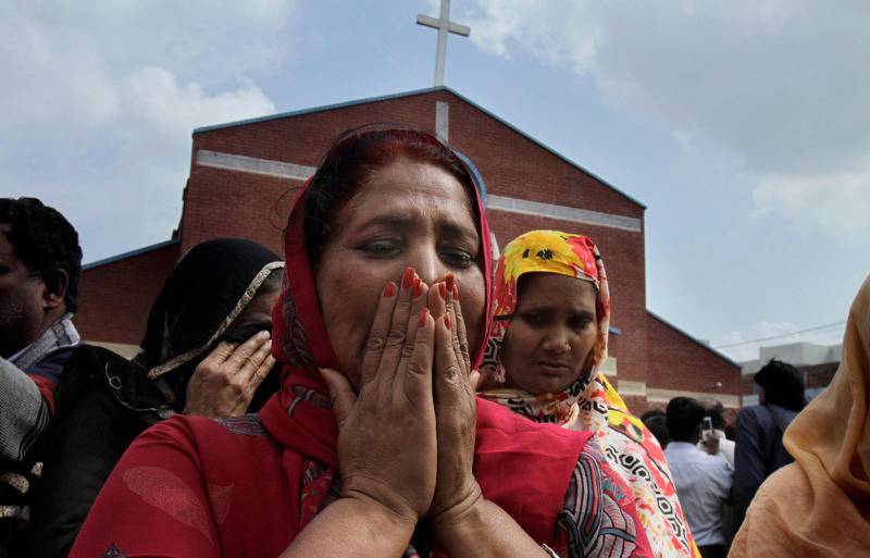En kvinna sörjer utanför en skadad kyrka i Lahore, Pakistan, 2015.