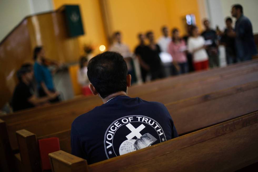 En asylsökande iranier väntar på att få bli döpt i kyrkan Trinity Church i Berlin.