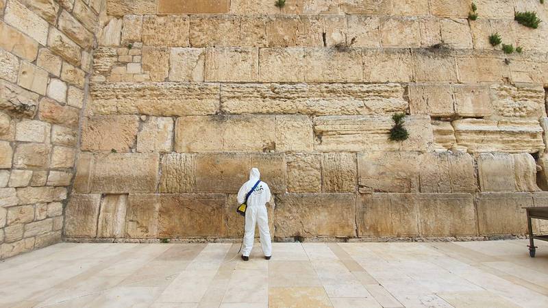 Västra muren i Jerusalem sanerades på tisdagen mot coronaviruset samtidigt som tiotusentals bönelappar plockas bort ur murens springor.