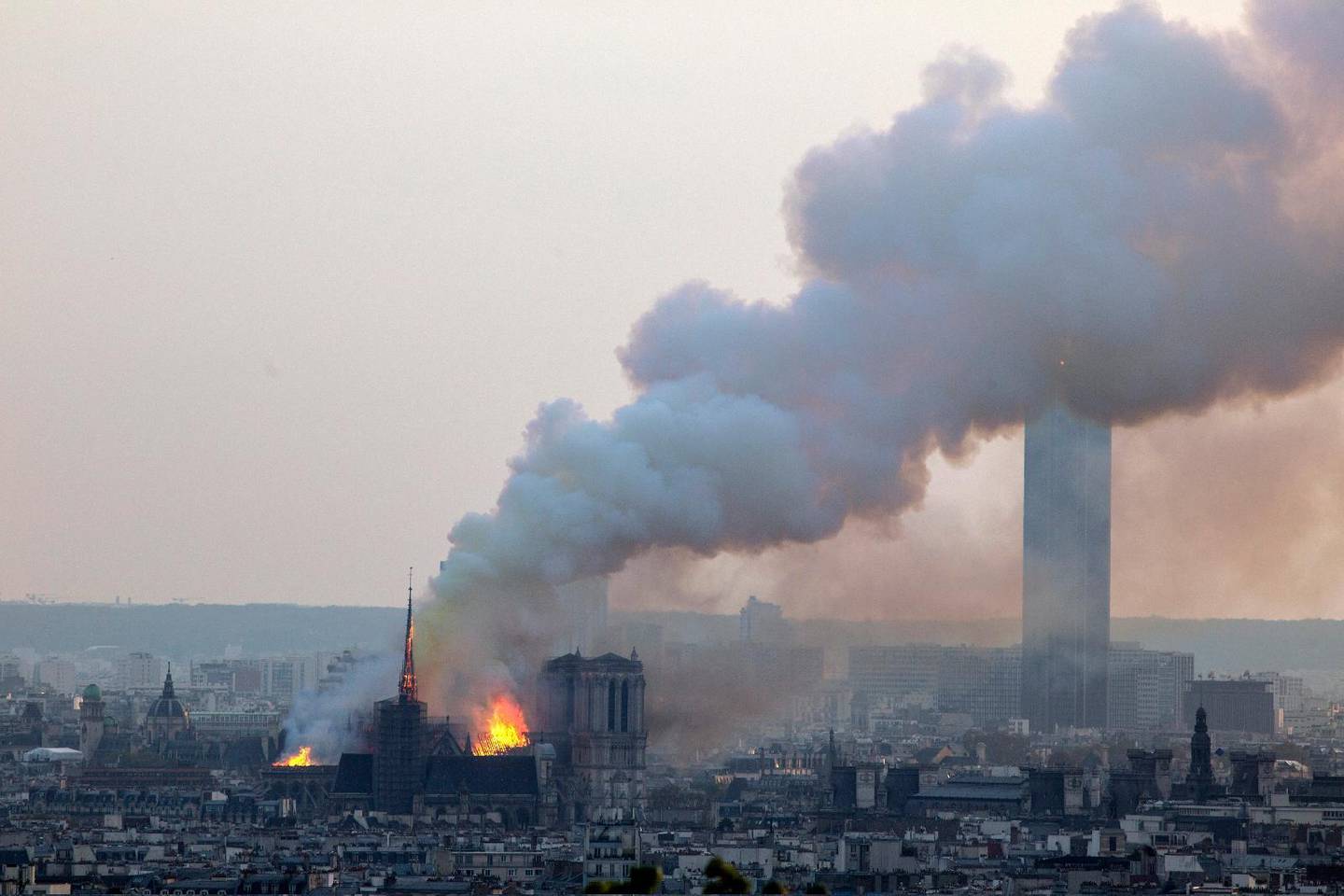 Notre Dame cathedral burning in Paris, Monday, April 15, 2019. Massive plumes of yellow brown smoke is filling the air above Notre Dame Cathedral and ash is falling on tourists and others around the island that marks the center of Paris. (AP Photo/Rafael Yaghobzadeh)