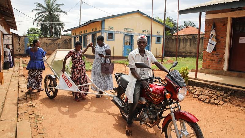 Justine i motorcykelambulansen utanför förlossningskliniken i staden Nyanza Lac, som ligger 3 km från hennes hem.