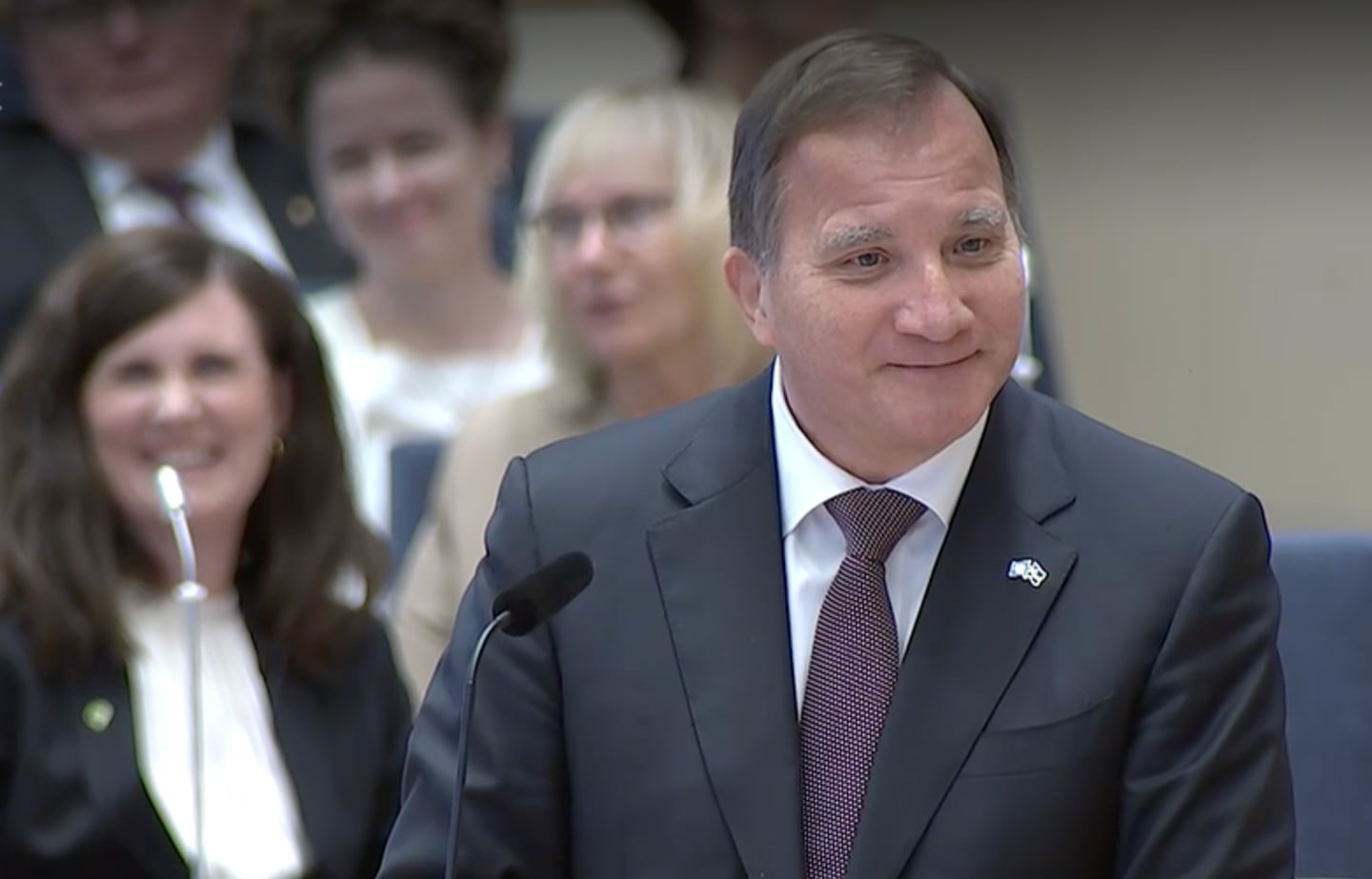 Stefan Löfven ler i riksdagen.
