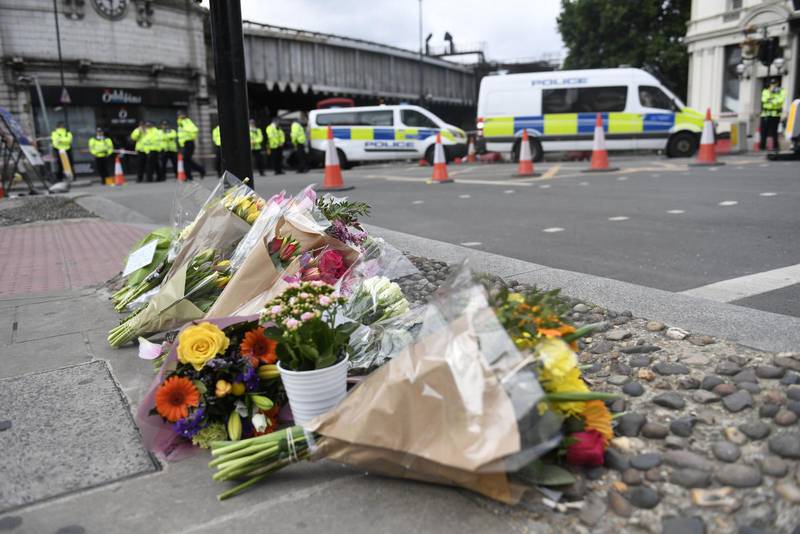 Blommor på trottoaren vid södra sidan av London Bridge där en skåpbil körde in bland folk på lördagskvällen.