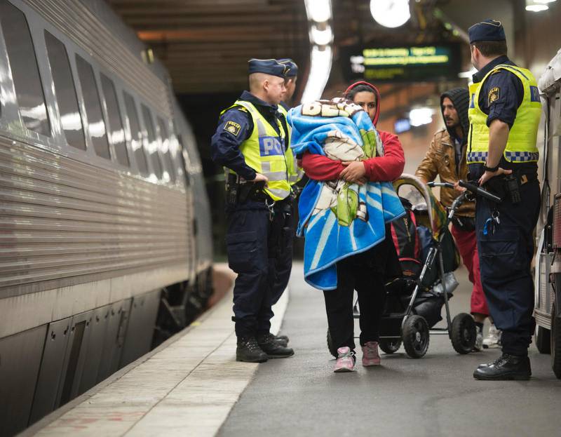På bilden syns en flyktingfamilj som anländer till Stockholm.