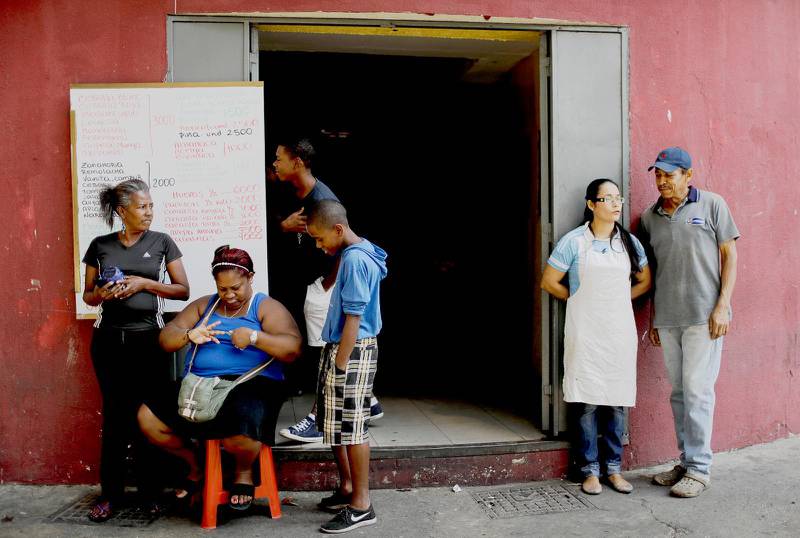 Invånare i Venezuelas huvudstad Caracas samlade utanför en livsmedelsbutik
