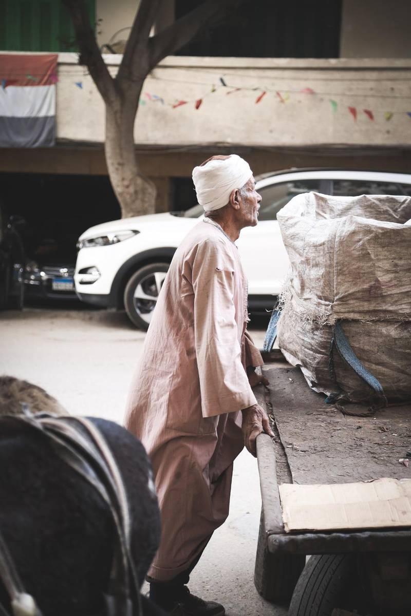 En man samlar in sopor på Kairos gator.