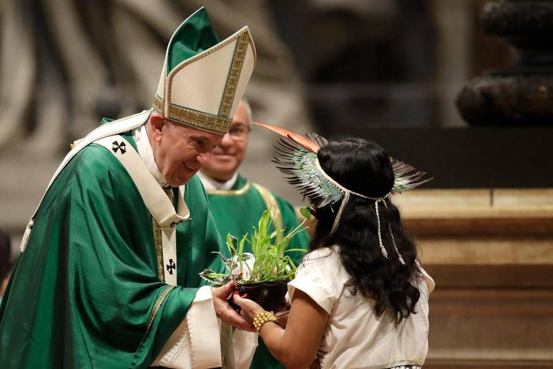 En flicka från Amazonas ursprungsbefolkning ger en planta till påven Franciskus under den avslutande mässan i Amazonas-synoden.