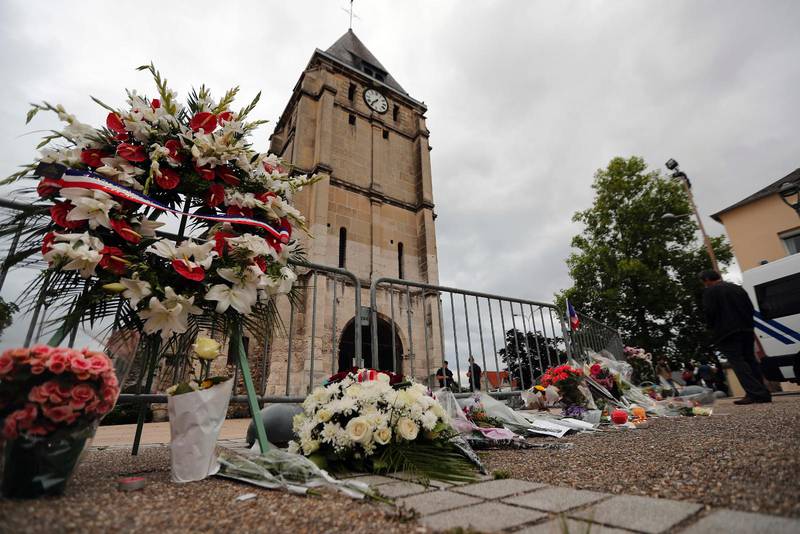 En krans av blommor från franska muslimska föreningar tillsammans med övriga blommor framför kyrkan i Saint-Etienne-du-Rouvray, Frankrike, där en präst dödades i onsdags. IS har med detta dåd gått över en ny tröskel i sitt krig mot västvärlden.