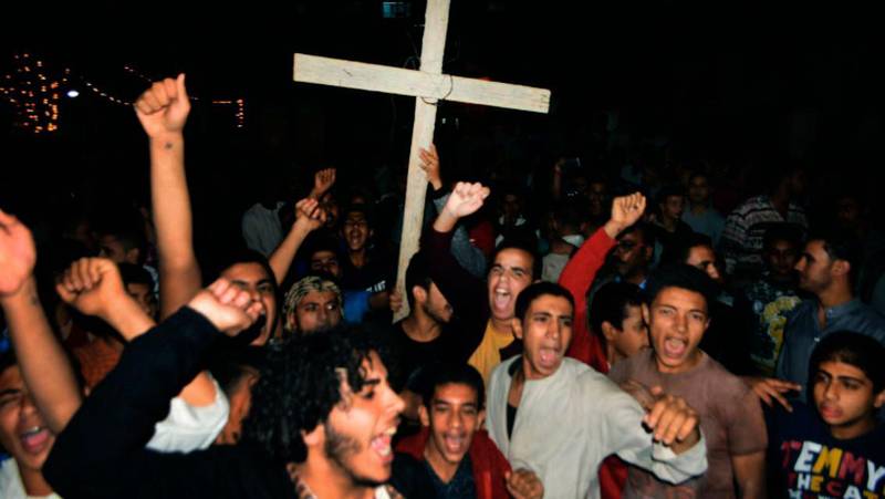 Kristna sjunger vid en protestaktion efter fredagens attack mot en buss, där sju personer dödades.