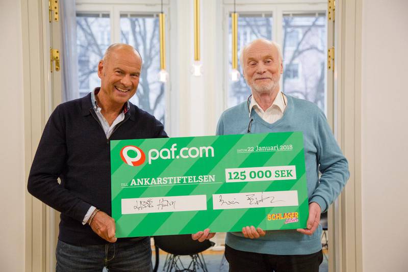 Lasse Holm överräcker en check på 125 000 kronor till Ankarstiftelsens grundare Börje Erdtman.