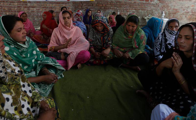 En grupp kristna pakistanska kvinnor ber i den kyrka som attackerades i helgen. Enligt polisen på grund av en konflikt om ett landområde.