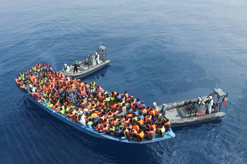 Besättningsmedlemmar från den irländska flottans fartyg Le Eithne hjälper migranter på Medelhavet. 