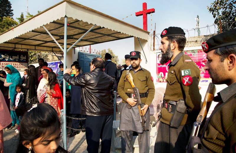 Pakistansk polis skyddar kyrkobesökare.