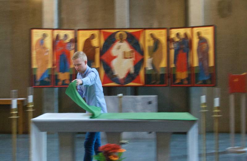 Sakristanen Axel Berg lägger vesperduken på altaret efter mässan.