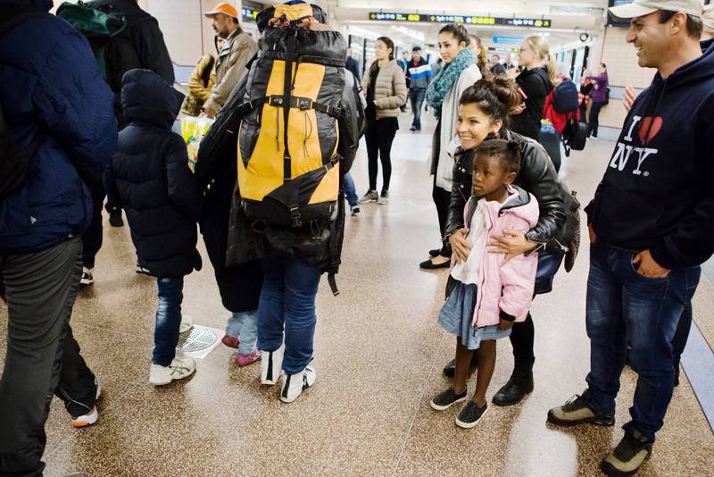 Carola och dottern Zoe välkomnar nyanlända flyktingar på Stockholms centralstation. 