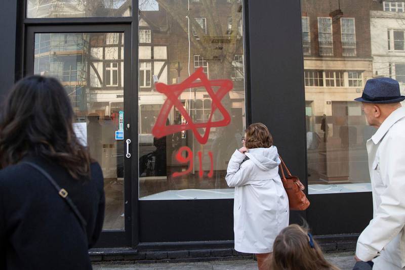 Antisemitiskt klotter på ett skyltfönster i norra London under den judiska högtiden hanukkah i december 2019. Flera synagogor och affärer utsattes för liknande attacker. Siffrorna 9 1 1 hänvisar till konspirationsteorin att judar var ansvariga för 11 september-attackerna 2001.