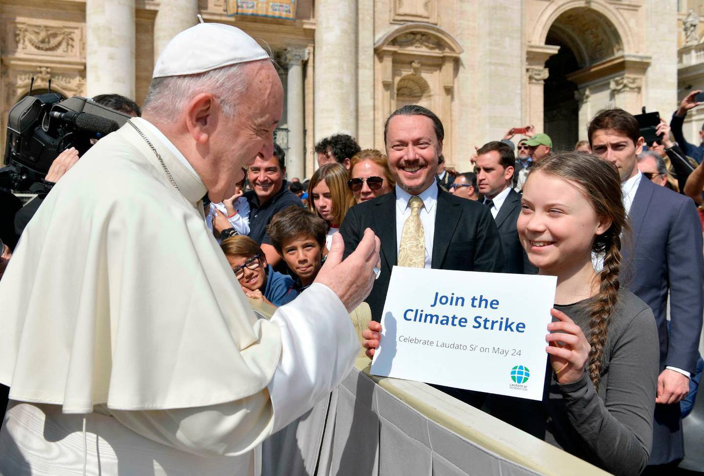 Swedish teenage environmental activist Greta Thunberg holds up a sign as Pope Francis greets her at the end of his weekly general audience, in St. Peter''s Square, at the Vatican, Wednesday, April 17, 2019. /thunberg has brought her climate change campaign to the Vatican, where she met with Pope Francis and carried a sign saying "Join the climate strike." (Vatican Media via AP)