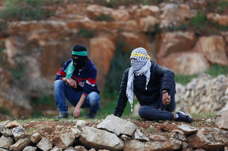 Två palestinier, en med grön scarf virad runt huvudet, vilket är Hamas symbol, och en med palestinasjal som har blivit symbol för Fatahrörelsen.