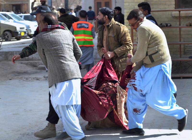 En skadad kvinna vid kyrkoattacken i Quetta, Pakistan, bärs i väg.