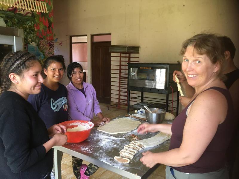 Ulrika Knuuth gör en insats i köket på barnbyn Vida Nueva i Bolivia. I landet lever nu alla i karantän.