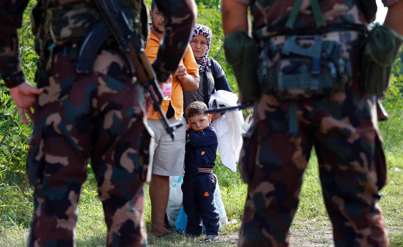 Ungerska soldater stoppar en invandrarfamilj vid gränsen mellan Serbien och Ungern