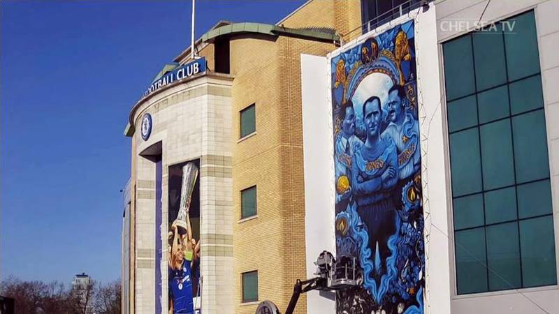 Konstnären Solomon Souza slutför väggmålningen vid entrén till Chelseas hemmaarena Stamford Bridge i London.