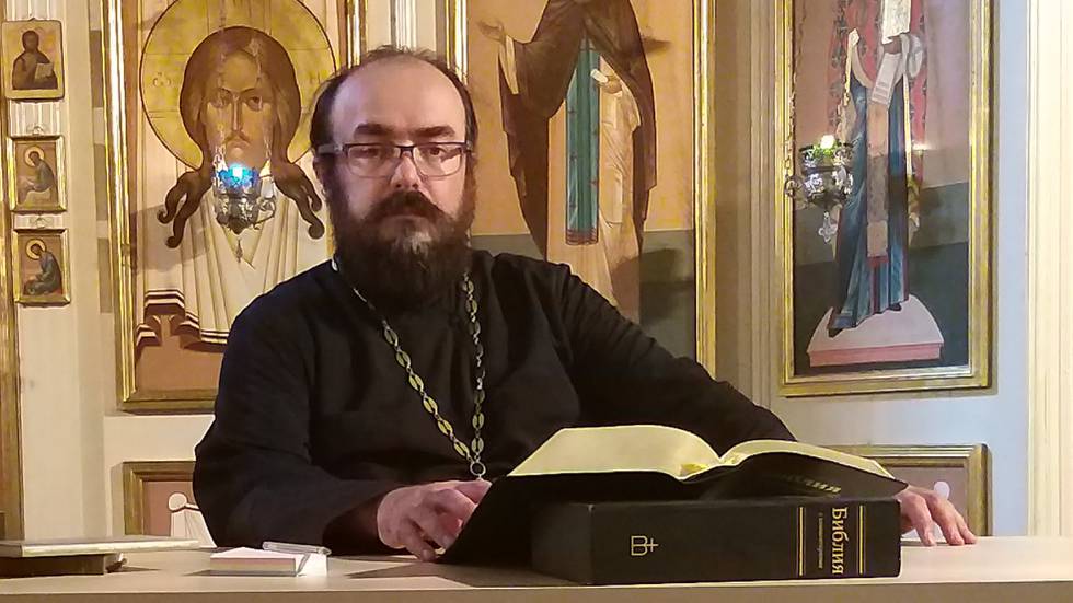 Sittande med bibel i ortodox kyrka.