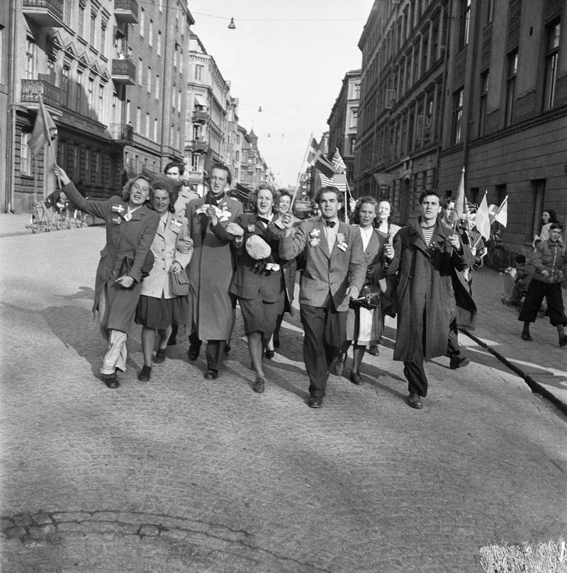 Fredsdagen den 7 maj 1945. Glada och flaggviftande människor firar freden längs Kommendörsgatan i Stockholm.