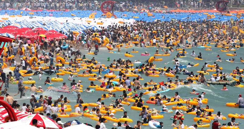 Sommartid är stranden Haeundae i Busan full av badande koreaner.