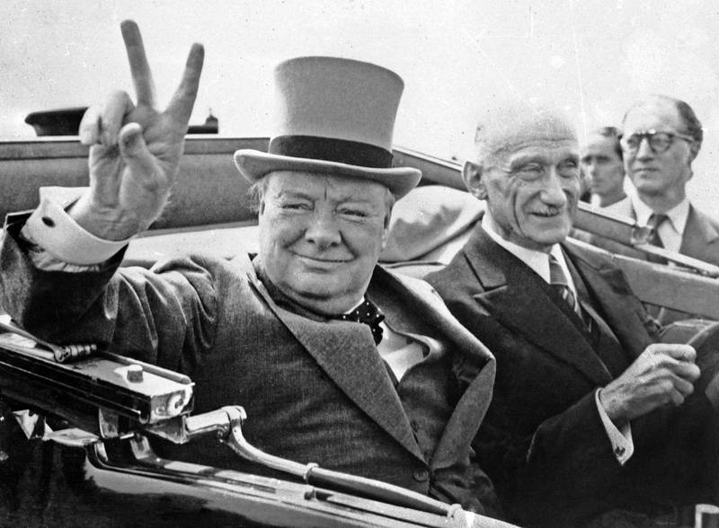 Winston Churchill, brittisk premiärminister 1940–1945 och 1951–1955, gör sitt världsberömda V-tecken när han besöker den franska staden Metz den 14 juli 1946. Bredvid honom sitter Robert Schuman som då var fransk finansminister.