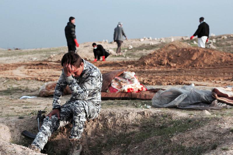 En irakisk polisman är förkrossad vid en massgrav som dolt IS offer.