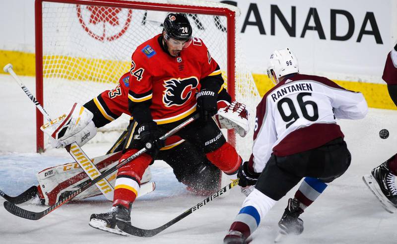Calgary Flames backgigant Travis Hamonic hjälper sin målvakt i en match mot Colorado Avalanche.
