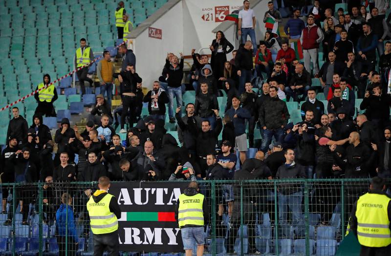 Bulgariska fans visar sitt hån och sitt hat medan säkerhetspersonal försöker lugna dem. England vann EM-kvalmatchen i Sofia mot Bulgarien med 6-0.