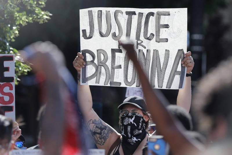 En demonstrant håller upp ett plakat med texten "Rättvisa för Breonna" i Louisville.