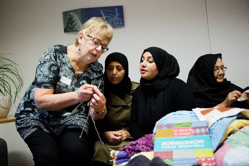 Kerstin Carlsson driver språkstickcaféet i Malmö ihop med vänner från Hyllie Parkkyrkan. Här visar hon Amal Abdu från Jemen och Sumaya Sahi från Irak hur de ska gå tillväga. Fatema Nazri från Afghanistan är mitt inne i sitt stickande.