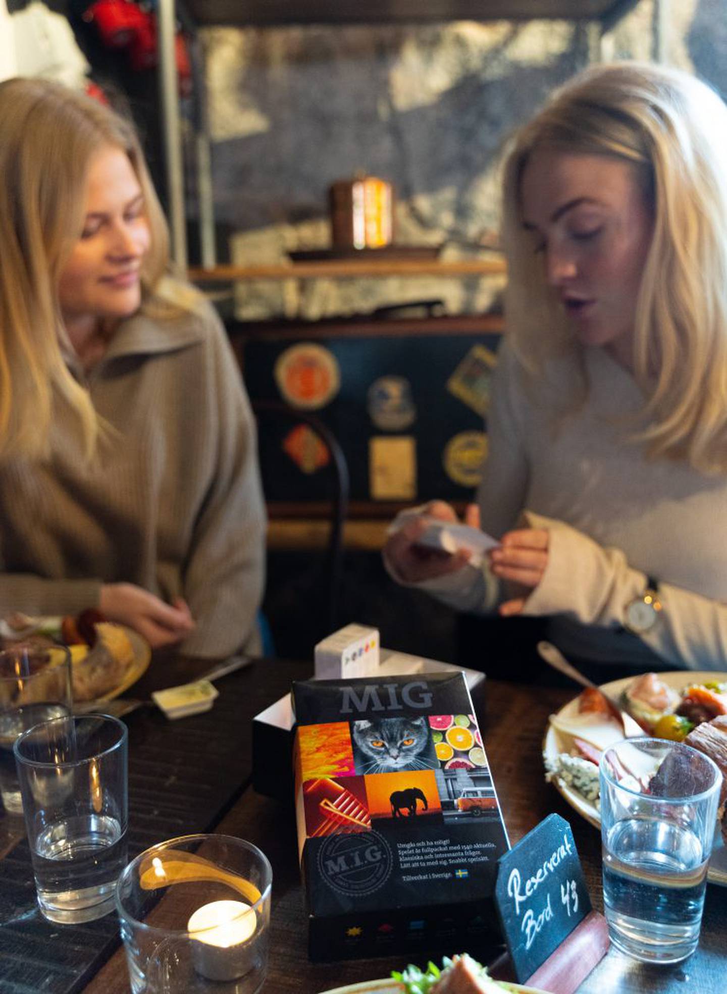 Två kvinnor spelar MIG Svart på en restaurang.