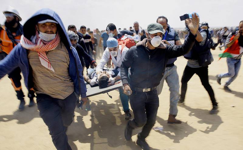 En skadad palestinier bärs bort för att få vård efter sammandrabbningar mellan palestinska demonstranter och israelisk militär. 
