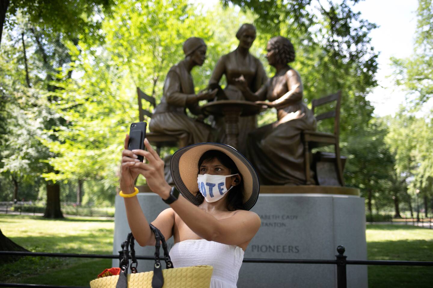 En kvinna tar ett foto framför den staty i Central Park, New York, som föreställer Sojourner Truth, Susan B. Anthony och Elizabeth Cady Stanton. Det är det första monumentet i parken som hedrar kvinnliga historiska figurer.